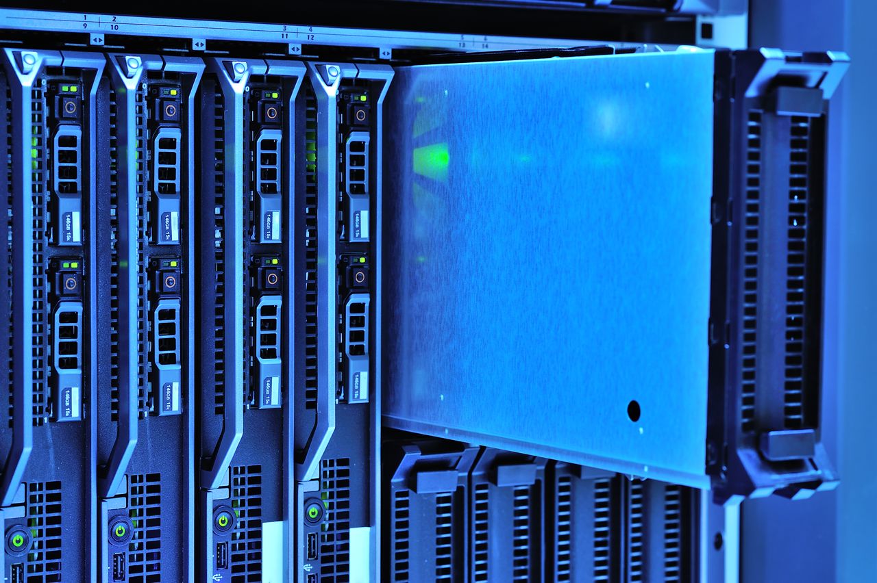 Enertek Detailed view of server racks with glowing lights in a data center environment.